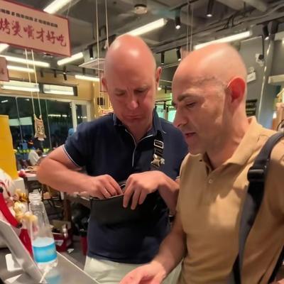 这两个老外在南昌吃烧烤，在前台结账时发现手机无法扫码支付，也没有现金人民币，老板