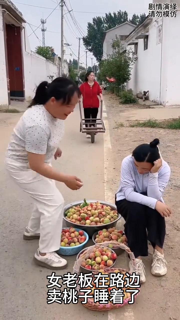 女子趁卖桃老板睡着拿走一筐，下一秒老板去追却被整蛊。
女老板在路边卖桃子睡着了，