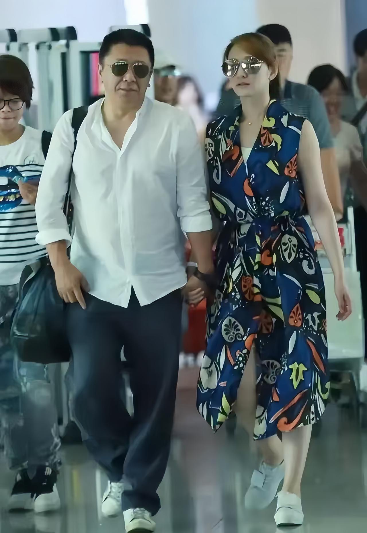 李小冉与老公徐佳宁走机场旧照，她老公戴着墨镜，看上去气度不凡，整体形象很不错。