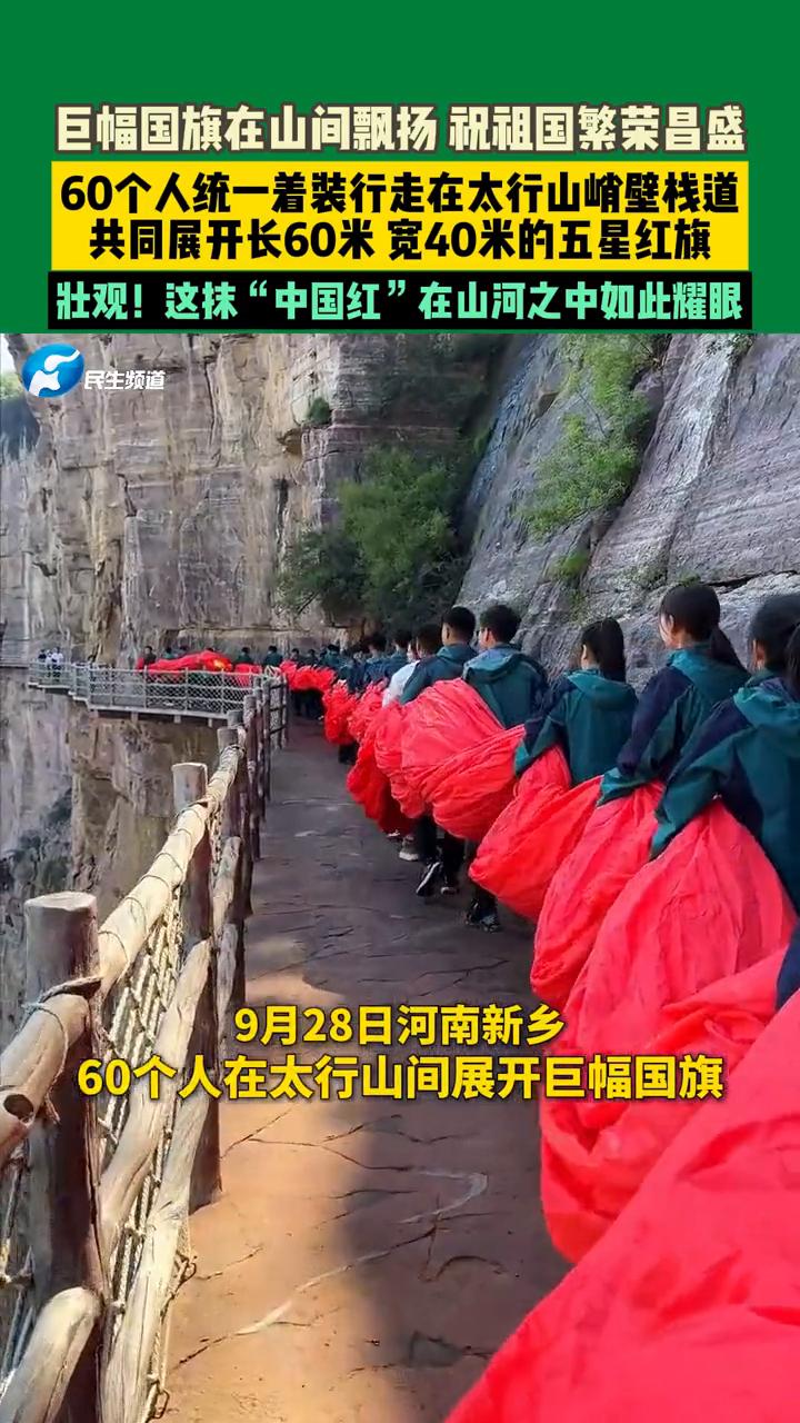 巨幅国旗在山间飘扬，祝祖国繁荣昌盛。
民生频道。
60个人统一着装行走在太行山峭