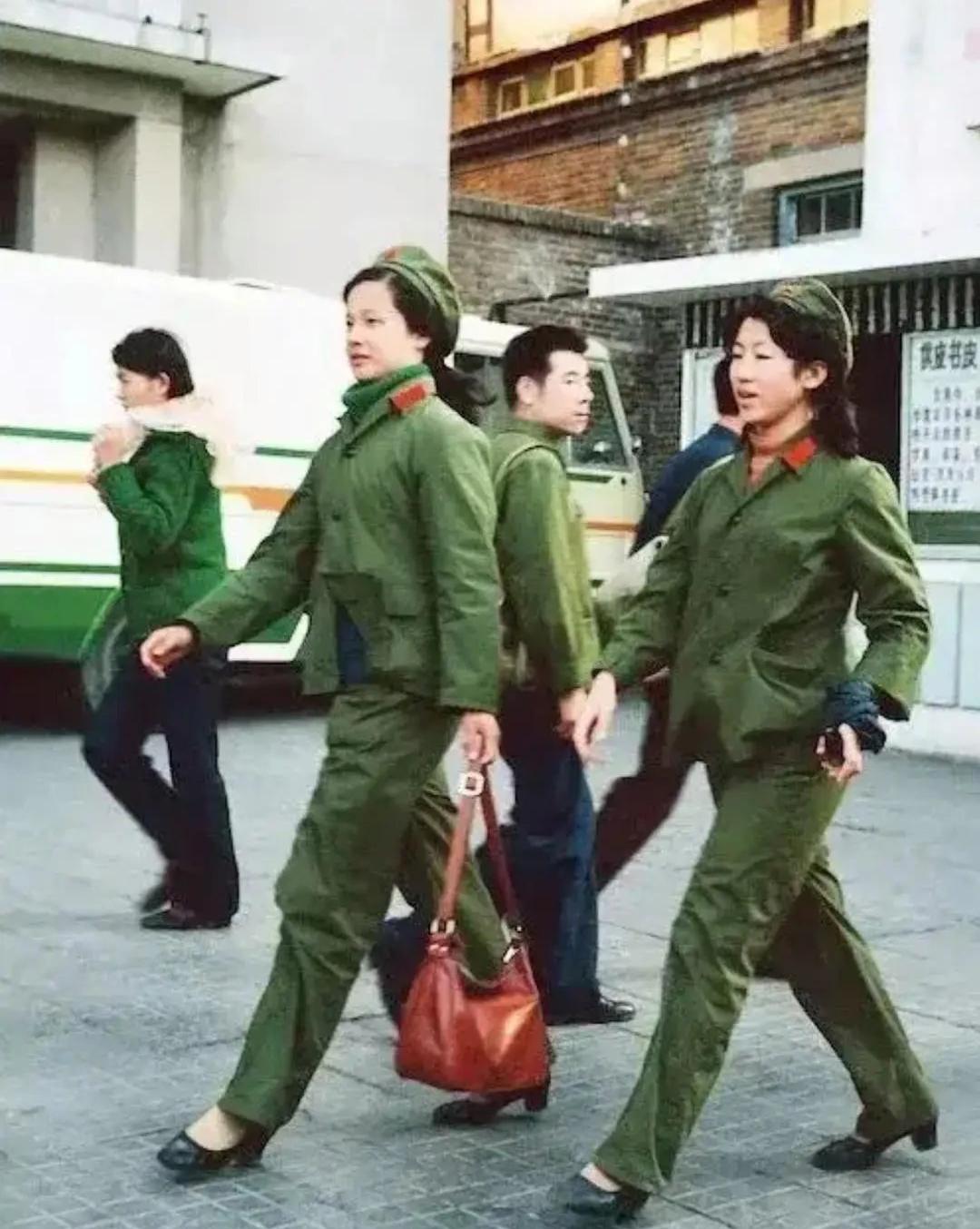 上世纪70年代，两位女兵以齐步姿势，昂首阔步行走在大街上。

她们身着65式军装
