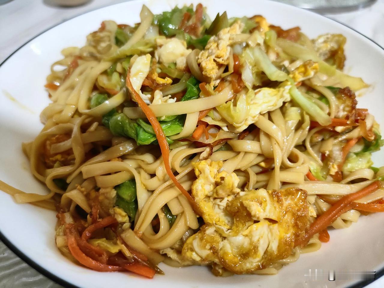 炒面的食材是挂面条，鸡蛋，圆白菜，胡萝卜。

挂面条煮熟后过水，控净。炒锅里放植