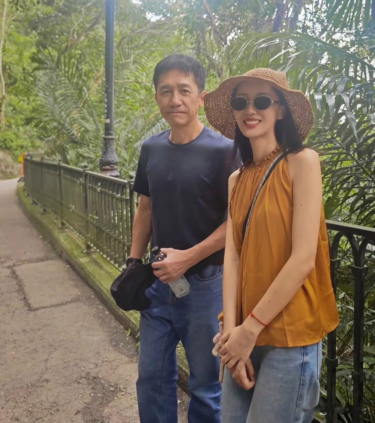 63岁梁朝伟在香港太平山顶被偶遇，他和最近合作的一位外国女导演在欣赏风景，穿着短