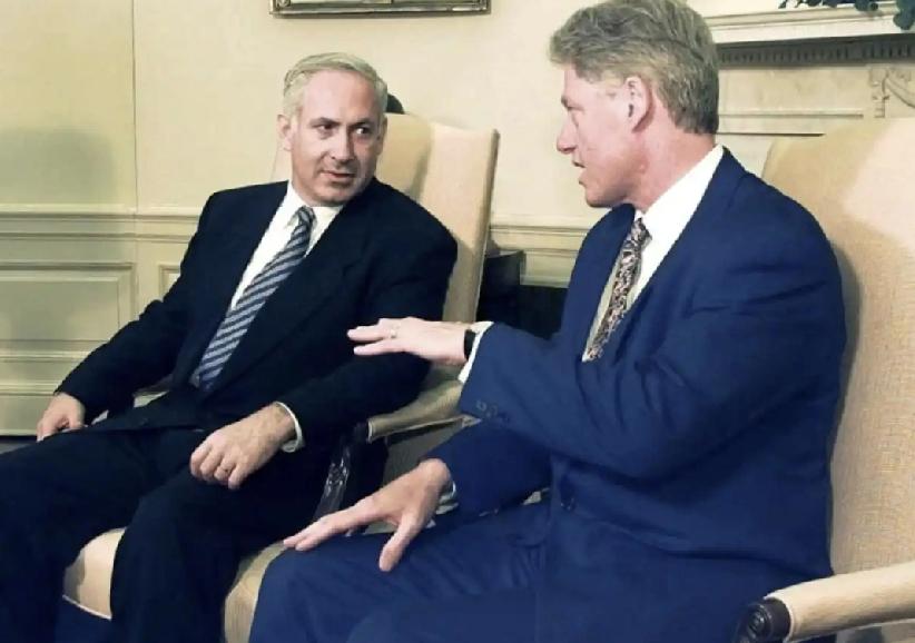 克林顿面前的内塔尼亚胡。
克林顿的左手掌心向下，不知在给内塔尼亚胡讲解什么，内塔