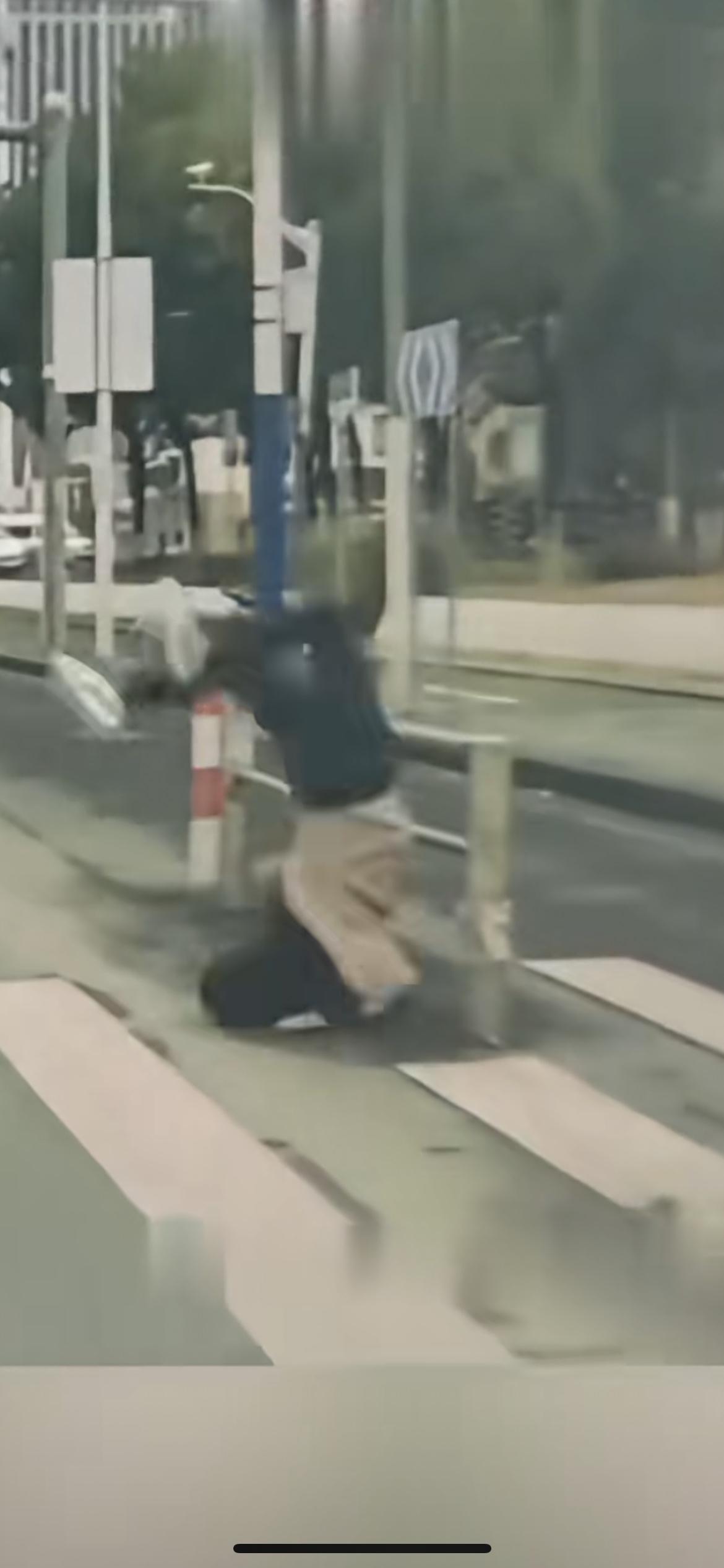 男子着急过马路“翻车”，只见他脚步匆匆，估计是有啥急事，被围栏绊倒，脸擦地面后空