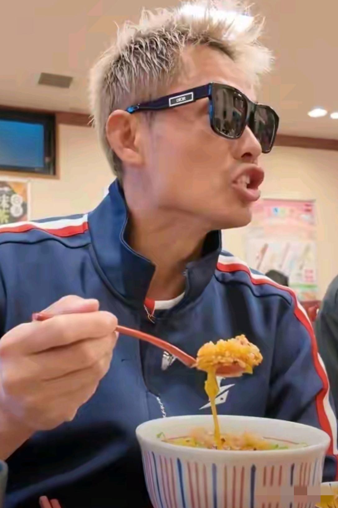林丹吃面被拍：画面中的林丹胖瘦适宜，头窄脸长，素齿如贝，淡金色头发醒目，宽边墨镜