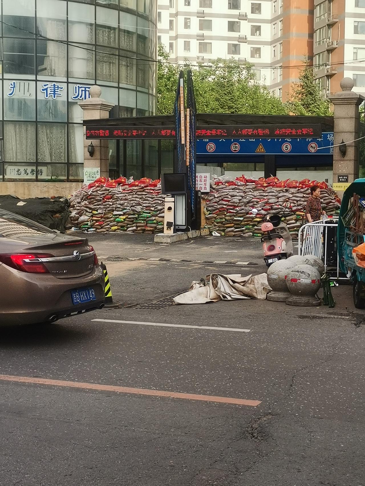 7 月 13 日，坐标吉林市，大唐江山地下车库门口堆满了沙袋，正为防汛做准备。