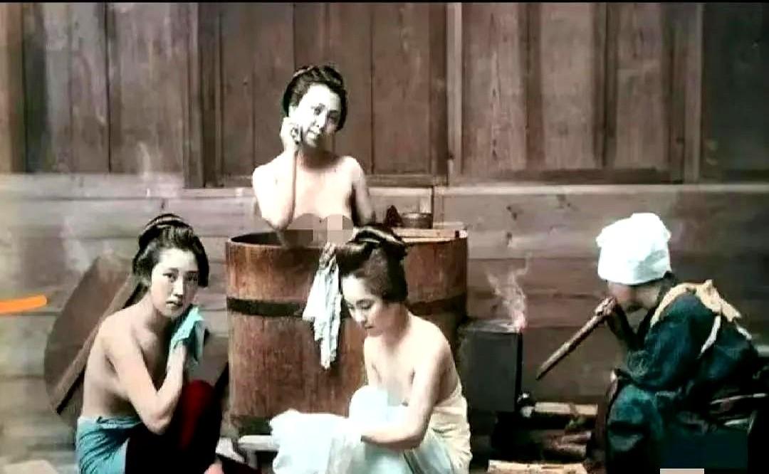 男仆蹲着吹火，镜头对准裸背，她们却笑得自然。

1890年东京小户家，三个女人泡