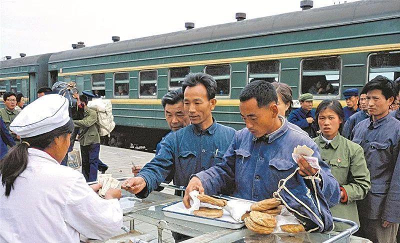 80年的绿皮火车，可以看到站台上还有卖饮食的工作人员，坐火车饿了的乘客在火车停靠