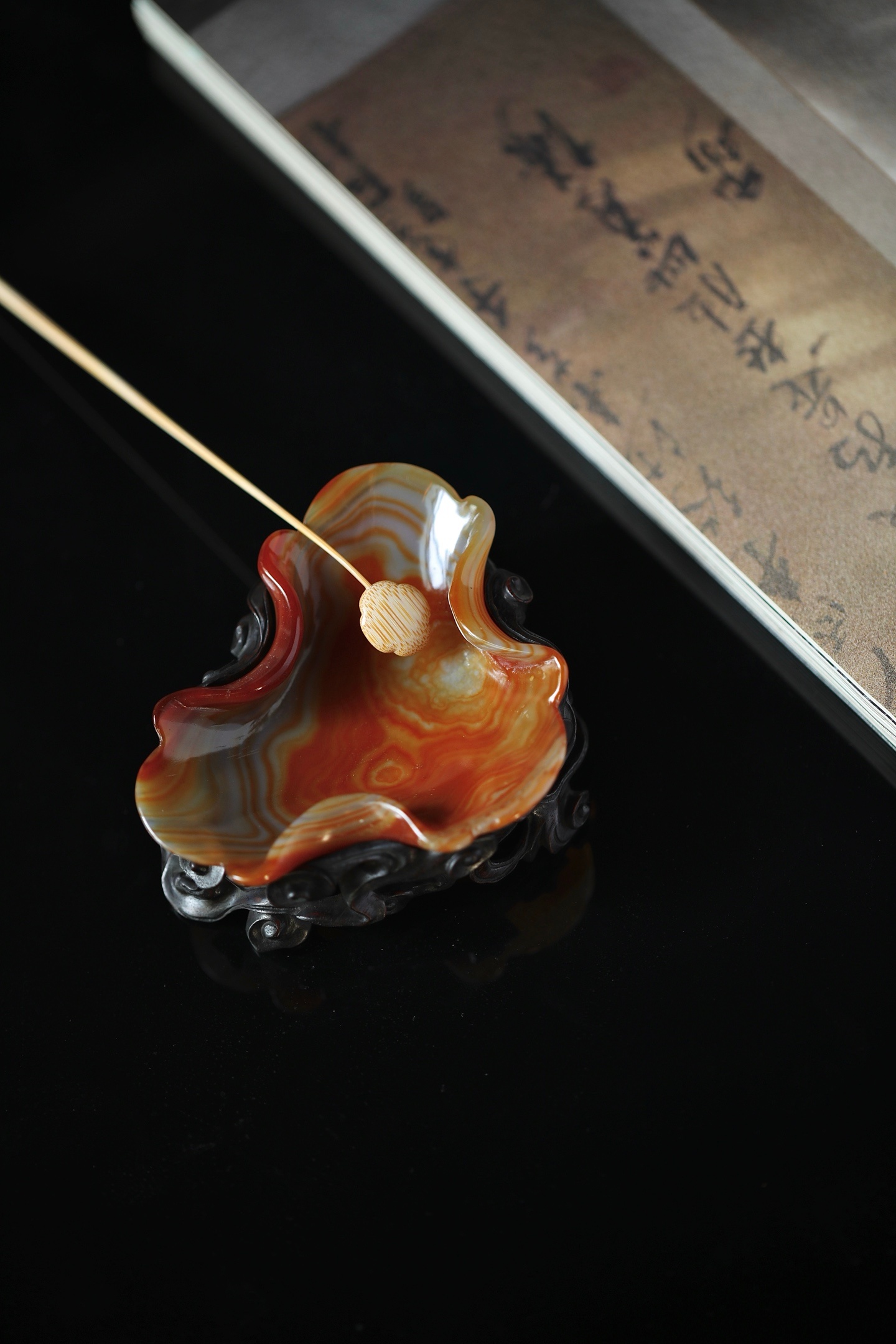 玛瑙 | 荷叶笔洗红玛瑙随形琢荷瓣，流云缟纹漫卷其间，边缘圆润如春水漾波，底座透