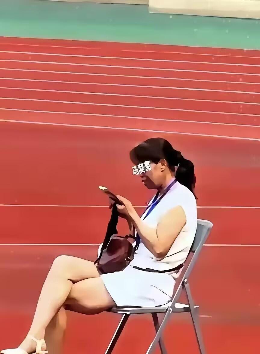 全网都在找这个甘肃陇超的女子是谁，她坐在一张椅子上，翘着二郎腿，刷着手机，脖子上