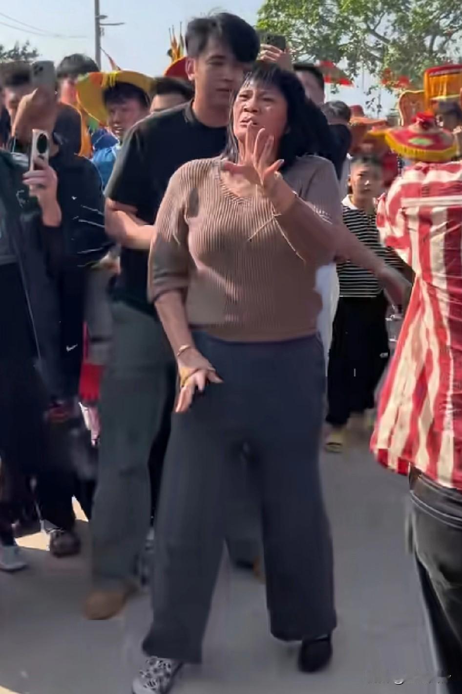 阿姨在旁边看热闹被选上了，面露痛苦神奇，手舞足蹈起来，家里人拉都拉不住
看热闹的