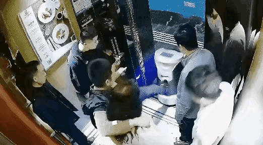 酒足饭饱一行人走进电梯，迎宾机器人紧随其后准备服务，不料被一名男子抬脚狠狠踹出电