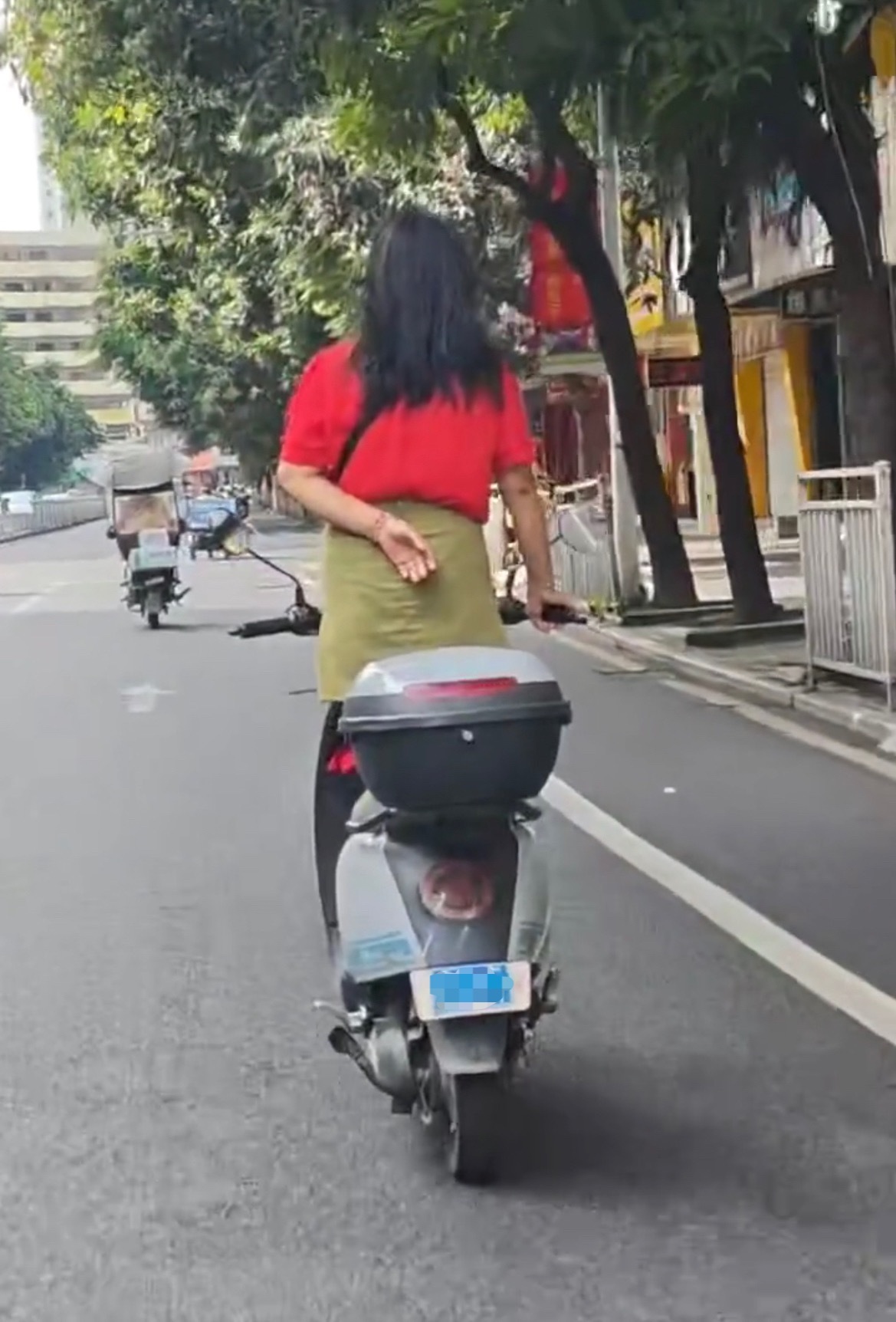 【玉林一阿姨单手抓手把站电动车上骑车】7月1日，网友爆料称：玉林市城区街头一阿姨