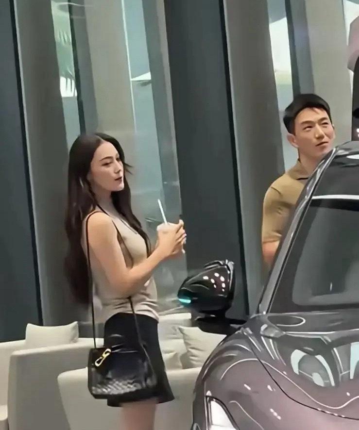 张馨予何捷广州逛新能源展厅，二人出行十分低调。何捷研究车辆配置，张馨予拿着奶茶在