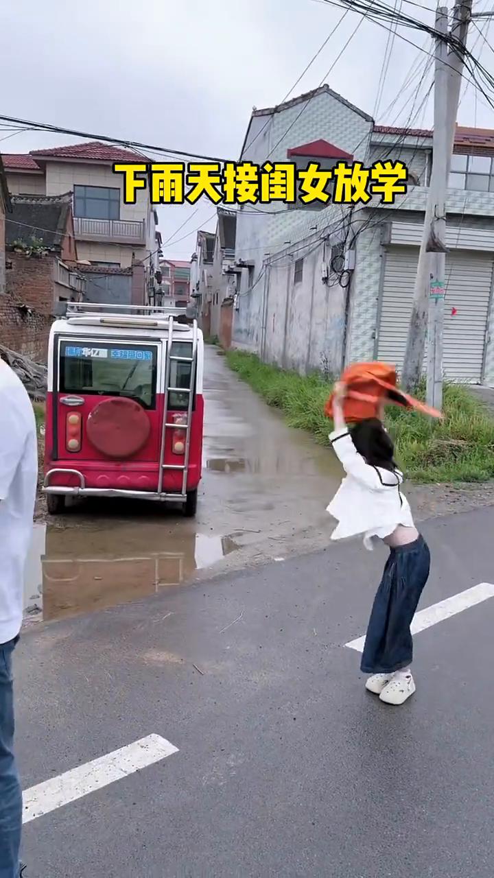 下雨天接闺女放学。