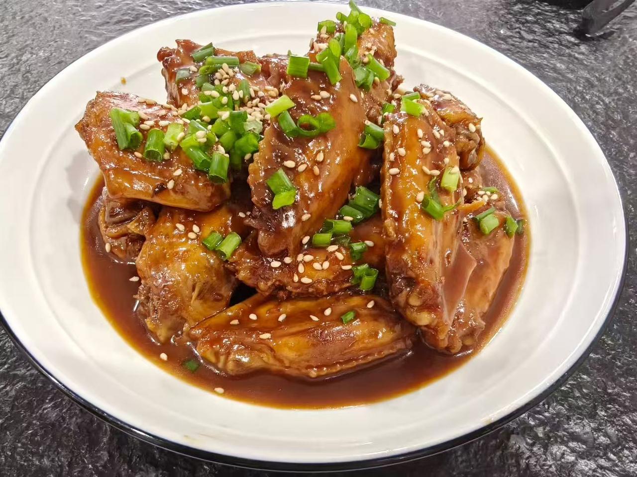 香浓酱汁的红烧鸡翅，撒上葱花和芝麻，美味诱人！🍲😋