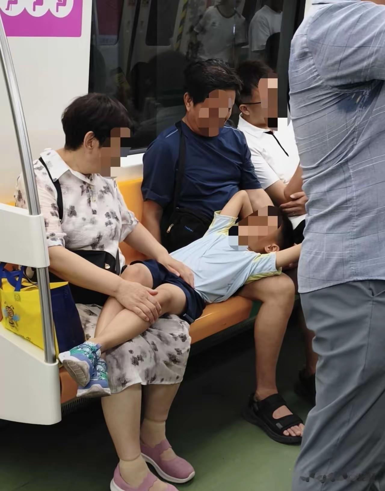 西安地铁上的一幕，
两个老人坐在座位上，
孙子仰面躺在两老的腿上睡着了，
网友为
