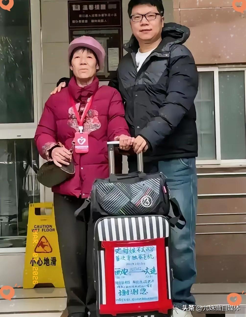 机场里，小伙子给丈母娘送行，老人的行李箱上贴着一张纯手工写的大海报，上面写着:“