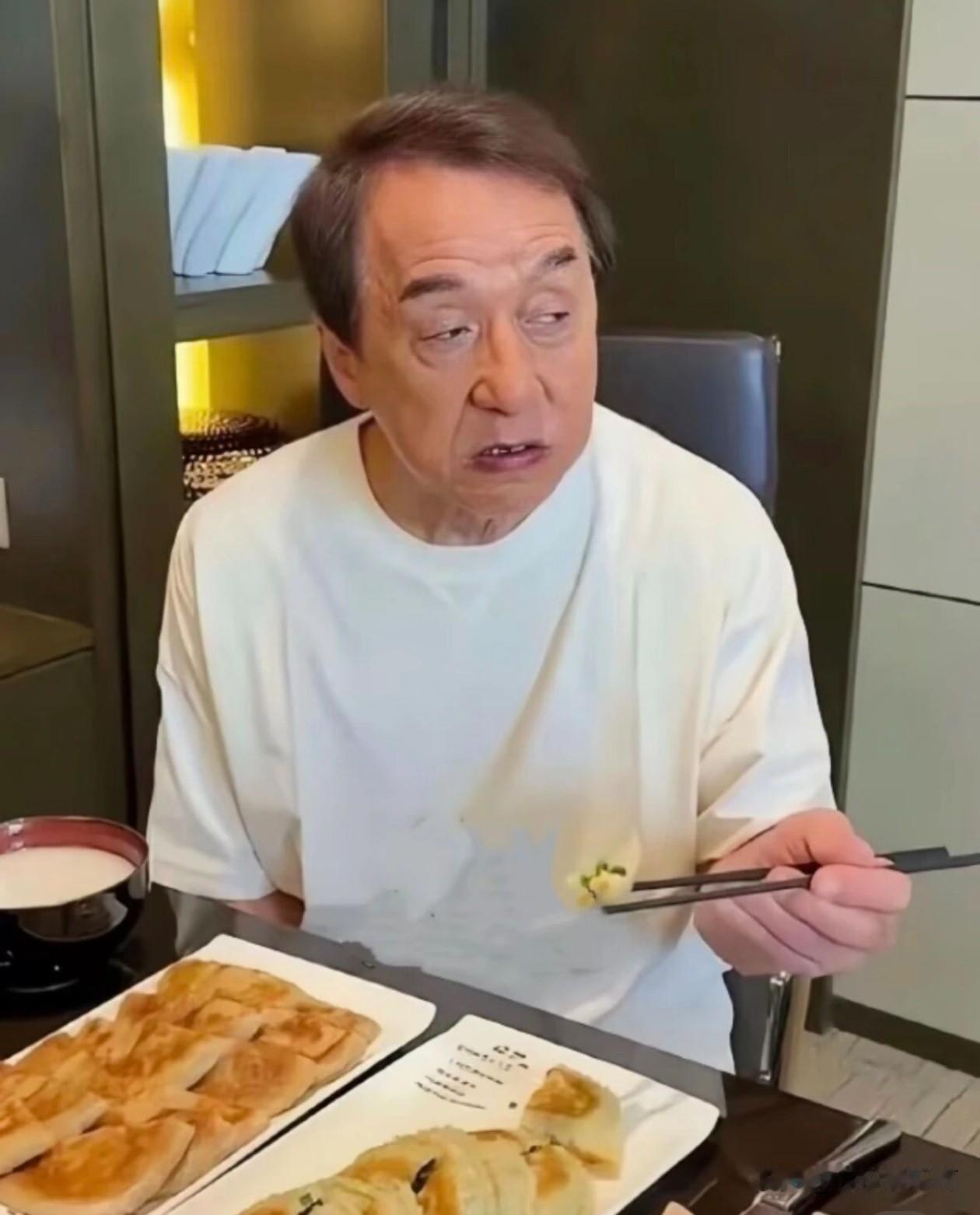 大家能认出这是谁吗？

对，是大明星成龙！

成龙在吃早点，这馅饼看上去像是韭菜