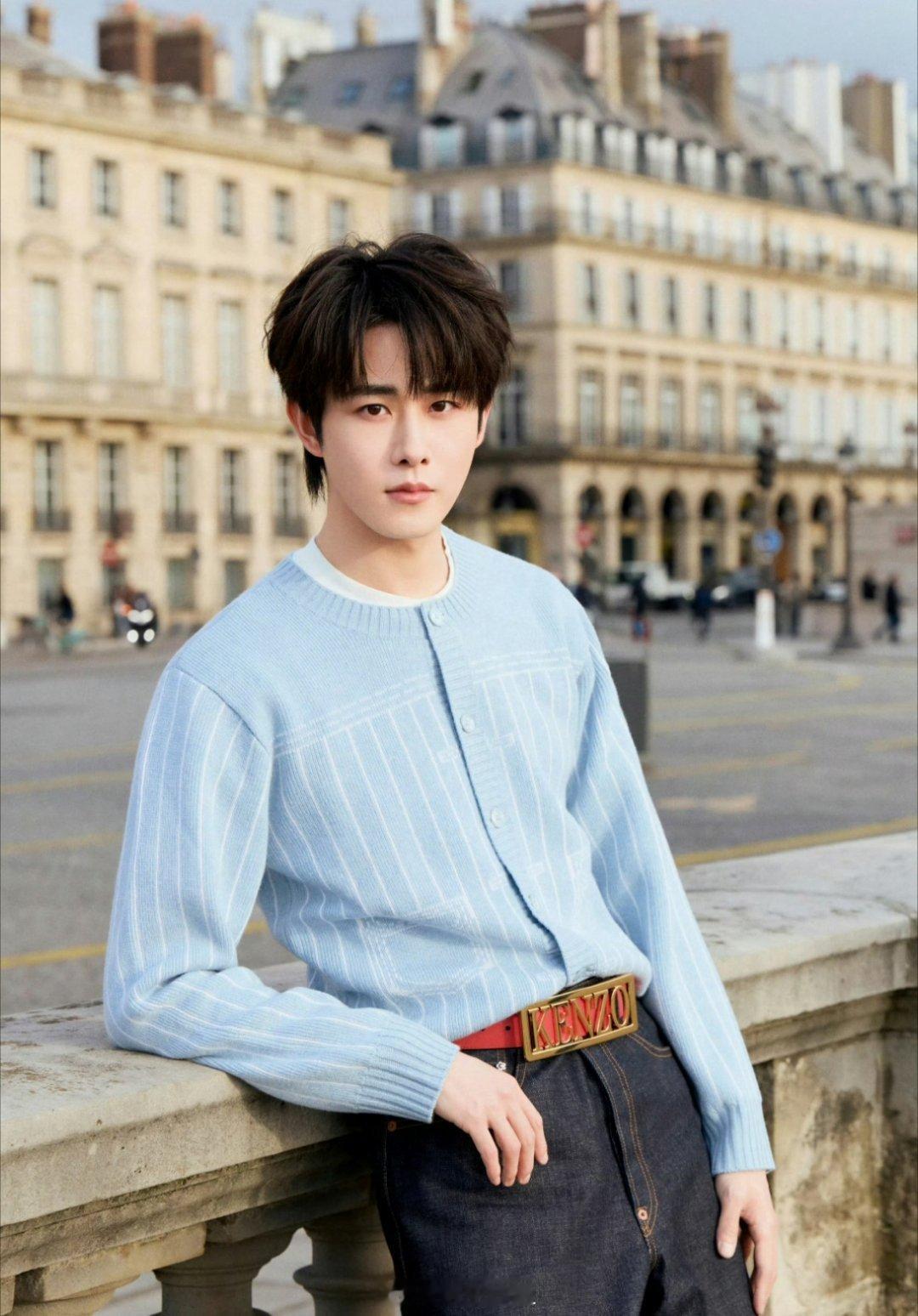 田嘉瑞的巴黎街头图，蓝色的毛衣搭配深蓝色的牛仔裤，小伙子冷冷酷酷的，长的也还行，