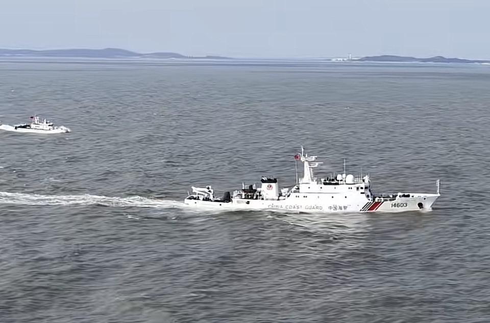 两艘巡逻艇在海上行驶，背景是岛屿。