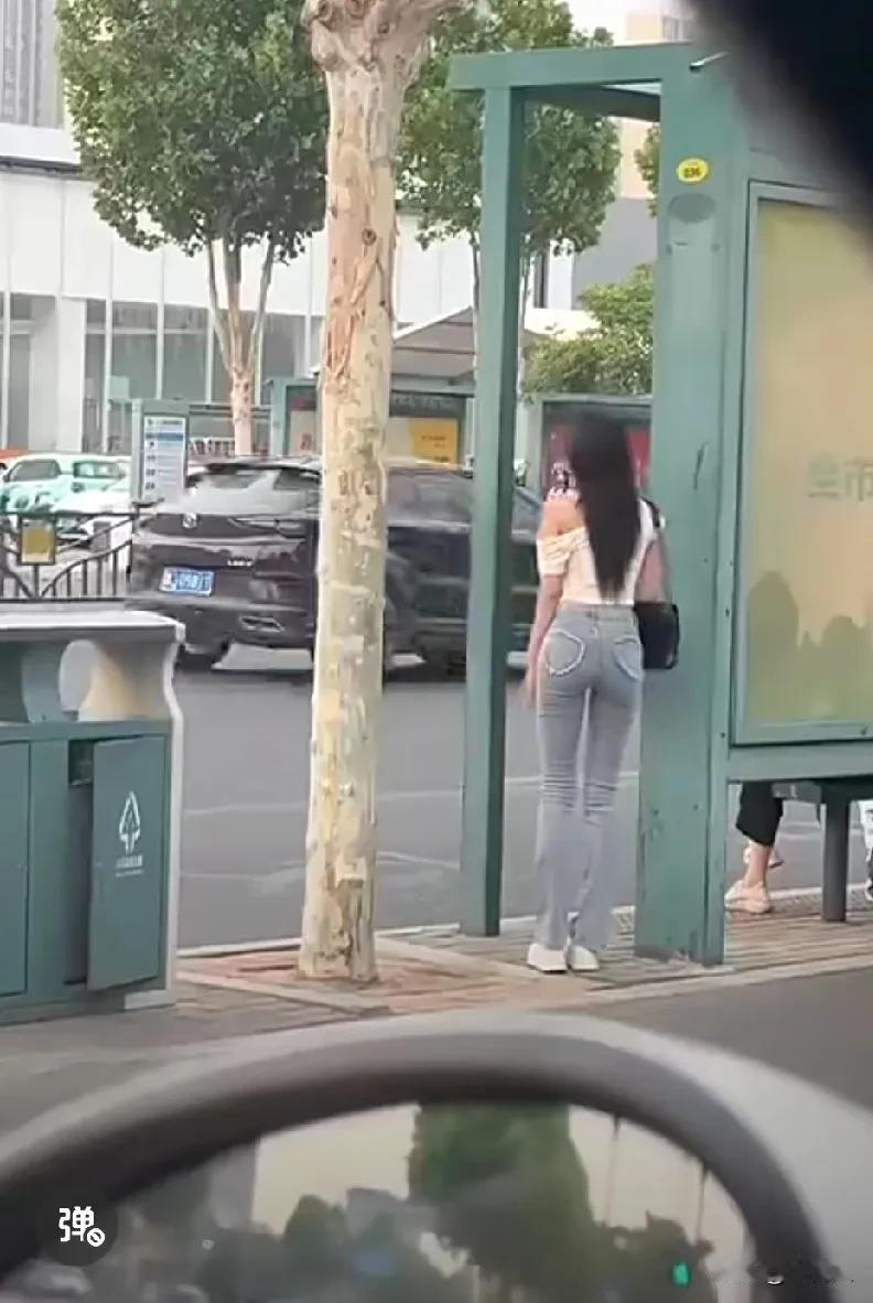一个女孩在公交站等车。