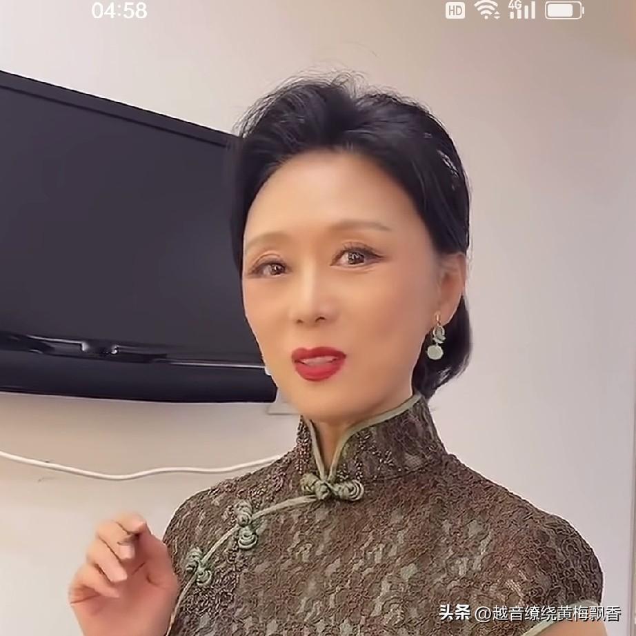 这是黄梅名家吴琼的穿旗袍在舞台上的形象，戴上发片的经过精心妆扮的吴琼一点也不显老