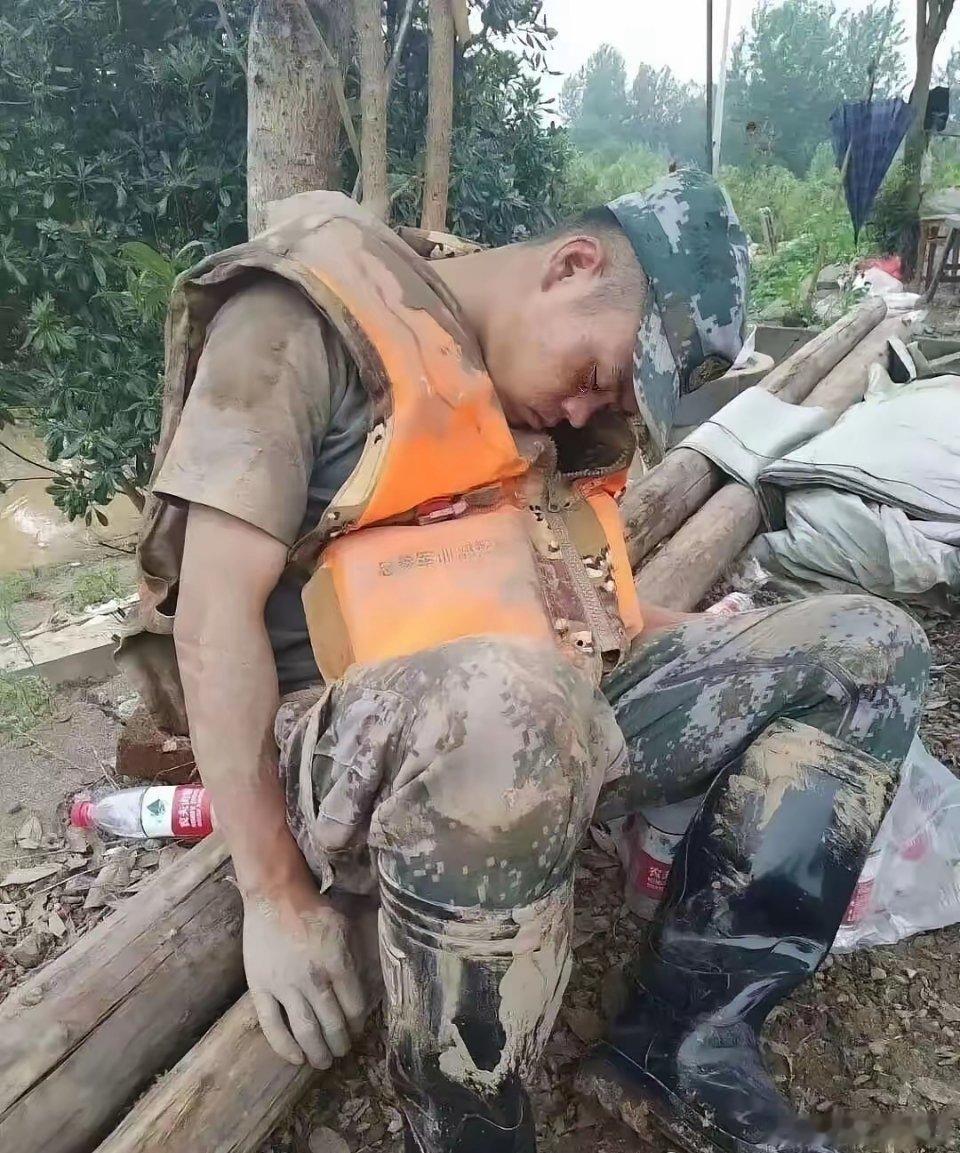 这张照片让无数人泪崩，一个满身淤泥的战士，累的靠在一棵树旁睡着了。每每看到这些冲