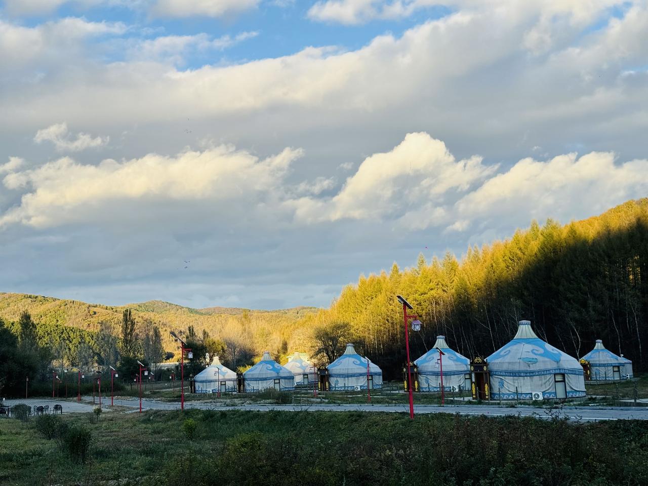 站在赤峰喀喇沁旗的山顶，吹一吹内蒙与河北交界的风。金黄的林海与蓝白的蒙古包相映成