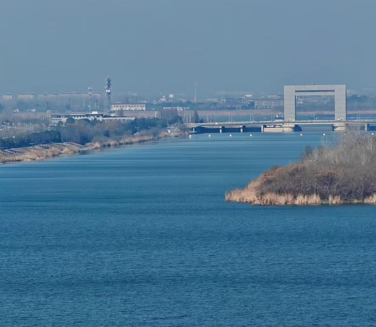 大桥如门，框住了城市的轮廓，也框住了这方天地的宁静。
风掠过水面，带着冬末的余温