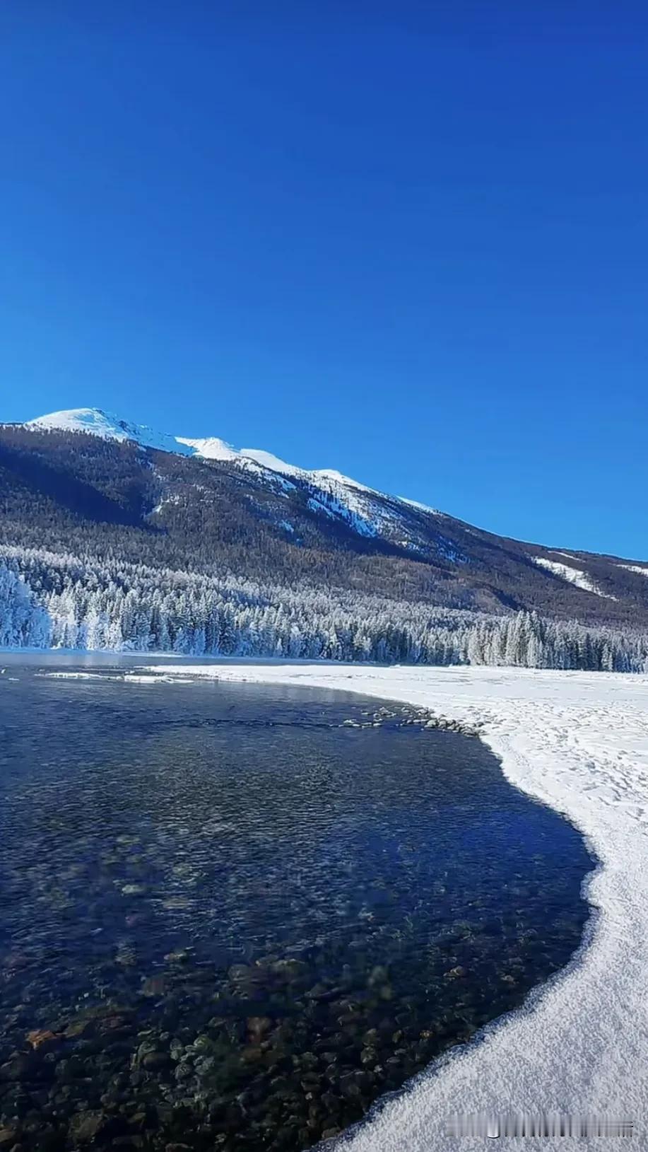 冬日雪山下的静谧湖泊，纯净如画。迷人的冬日景色 赏冬雪美景 湖边美景🌊