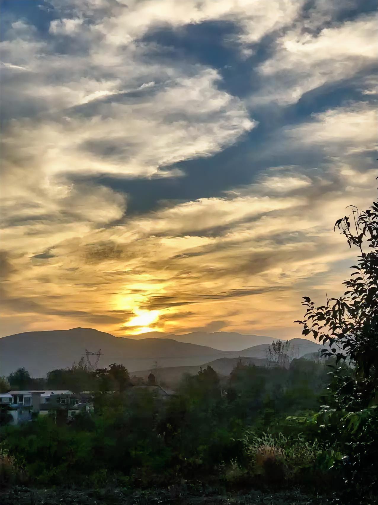 风里已经裹着草木的焦香，我蹲在田埂边看落日。
 
远山是层叠的灰，像被谁用炭笔轻