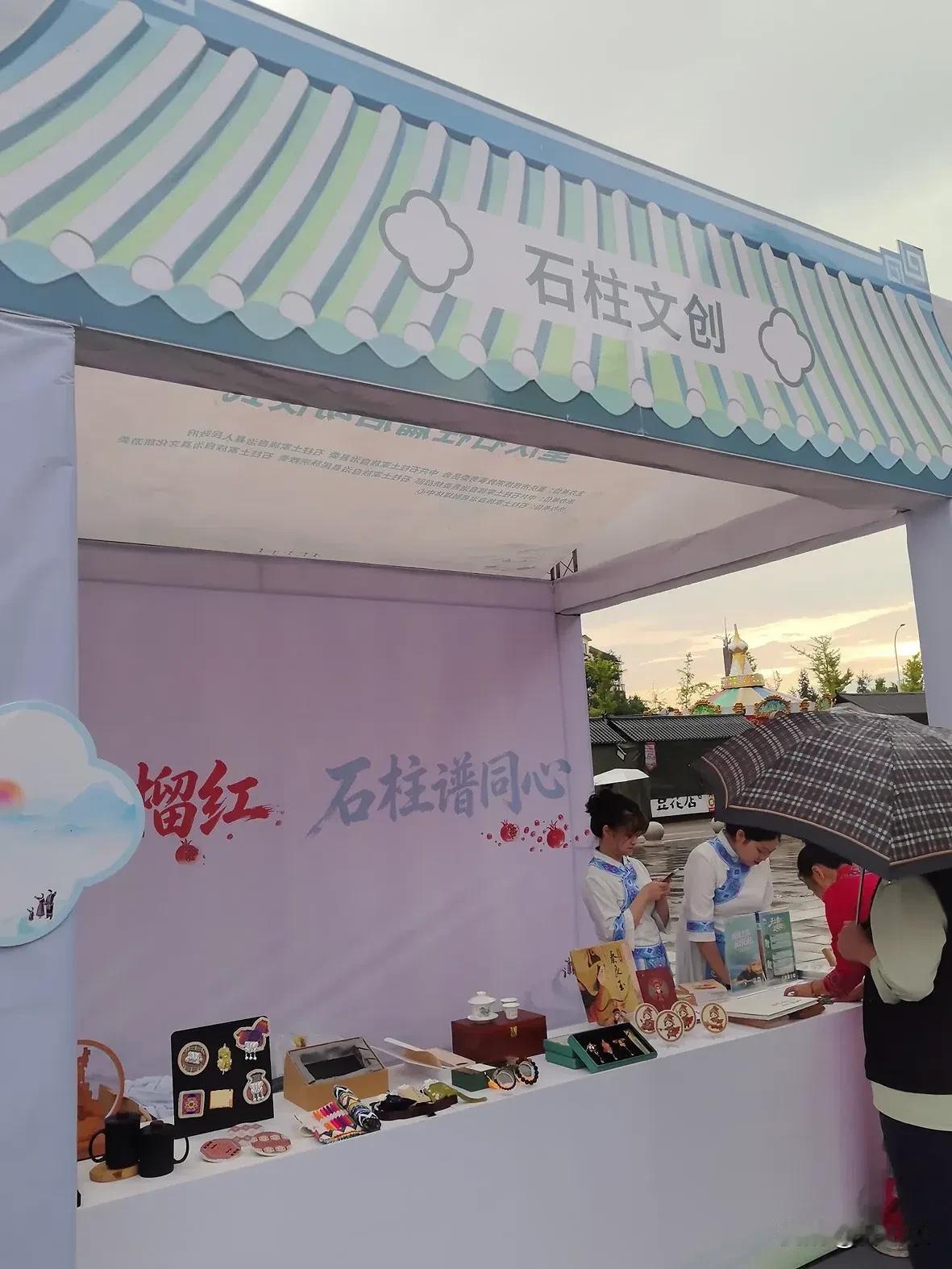 大剧院广场的文创摊，在雨中撑起了一道风景

雨中的大剧院广场，远处的摩天轮在灰白