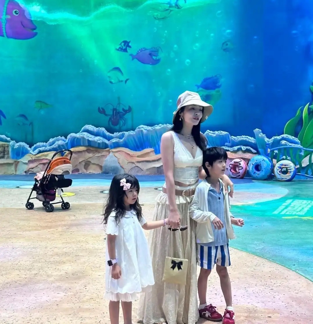 39岁麦迪娜和一对子女现身珠海长隆游玩，她打扮时尚又性感迷人，穿着一条白色裙子，