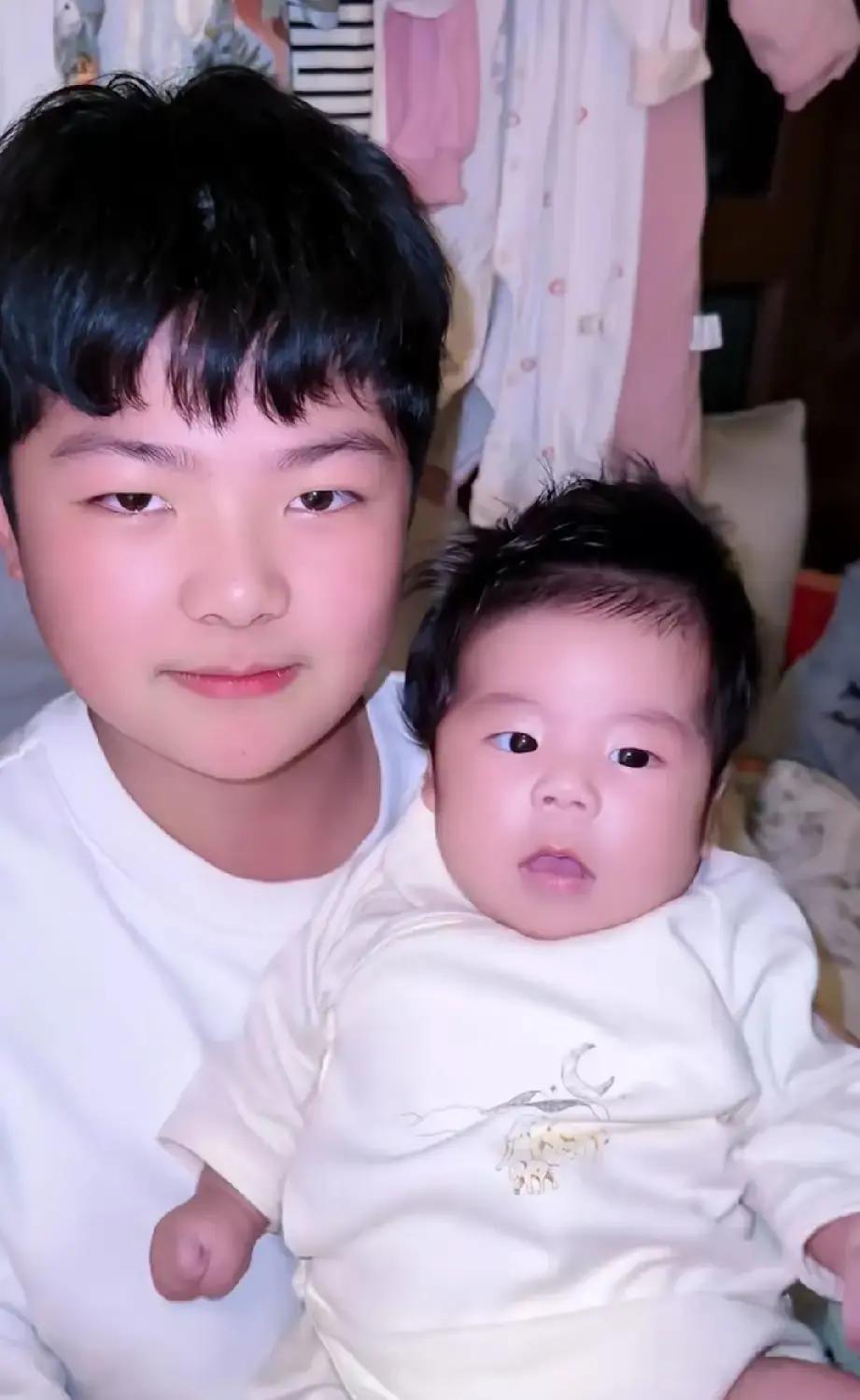 路嫂拍视频，三岁的子淳被递妹妹，他往后缩，说等一岁再抱。
镜头里姐姐子妍马上贴过