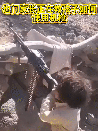 也门一名男子正在教他的孩子操作机枪射击？
这么小的孩子射击时却从容不迫，一点都不