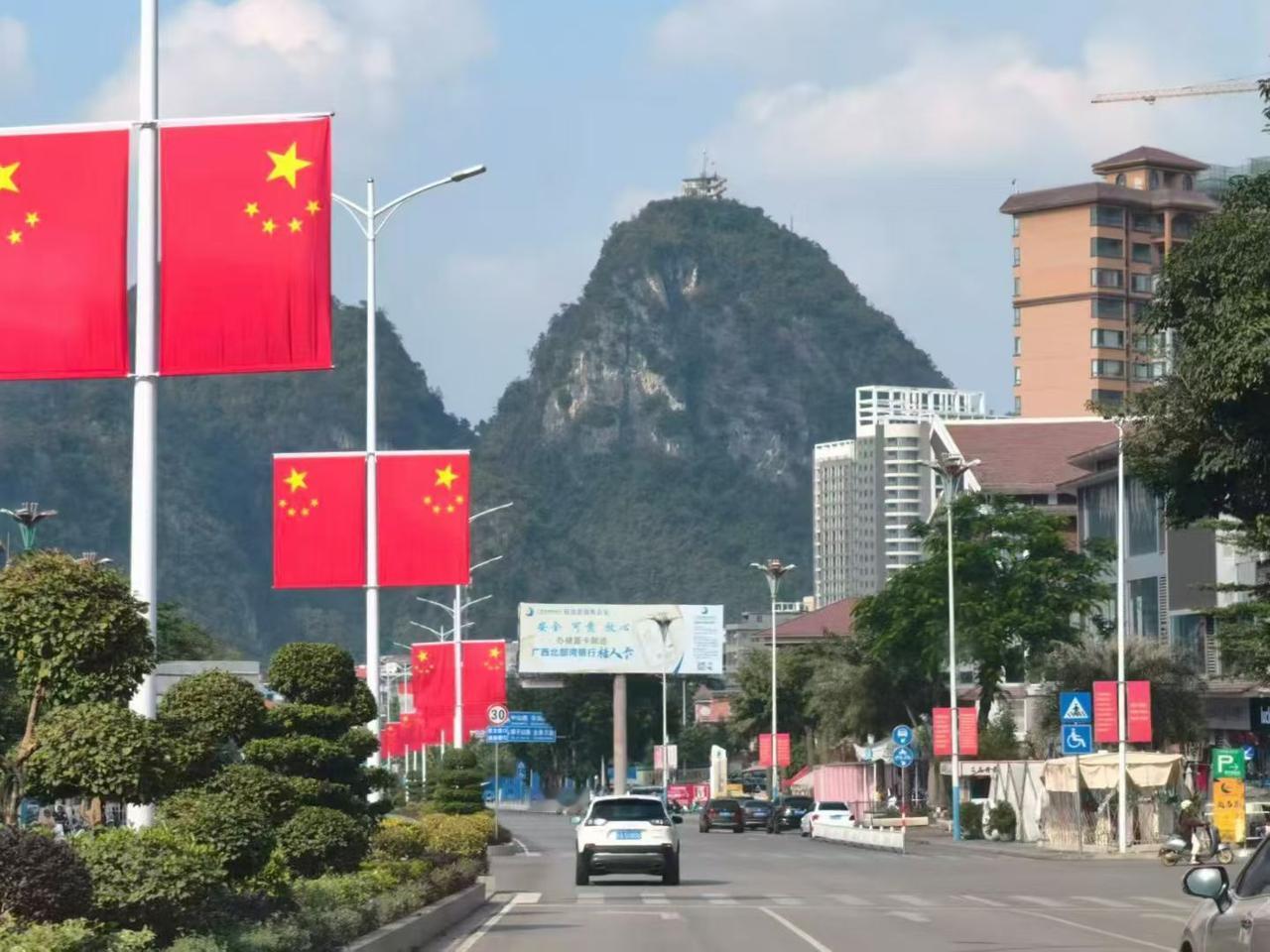 ✨红绸似的旗帜沿着街道生长，把山河的壮阔与人间的烟火，都织进这片滚烫的明媚里。