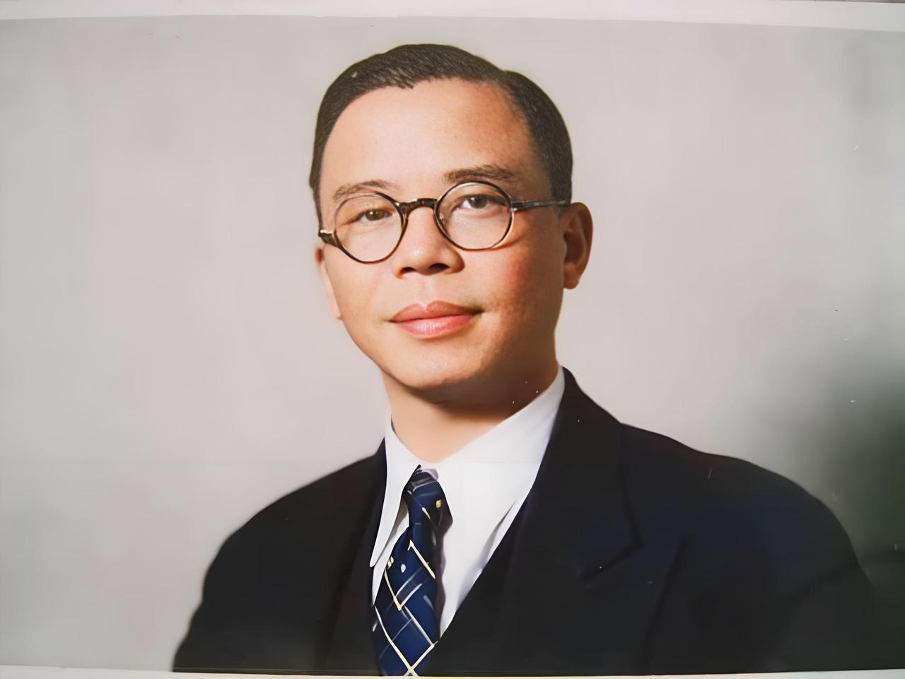这张照片中的蒋廷黻，身着笔挺的西装，搭配领带，戴着一副圆框眼镜，面容沉稳，眼神中