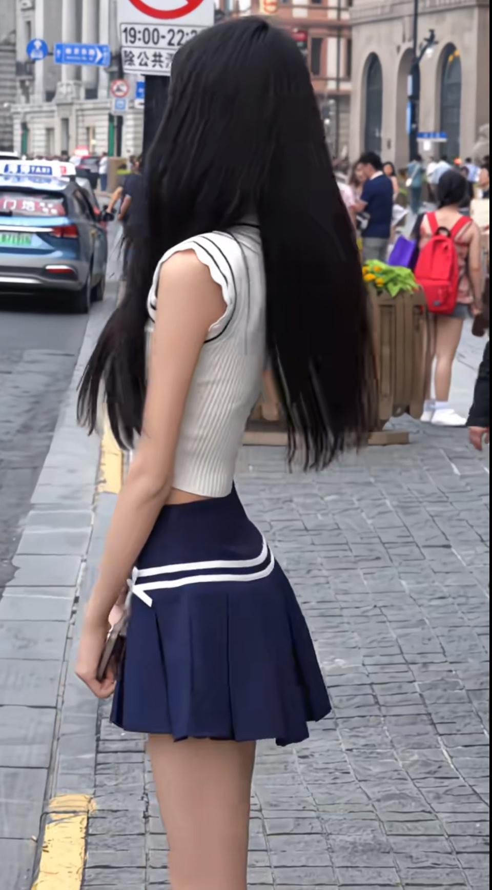 长发垂过腰的弧度，是夏末街头最轻盈的风。
水手领针织衫裹着松弛的甜，藏青百褶裙晃
