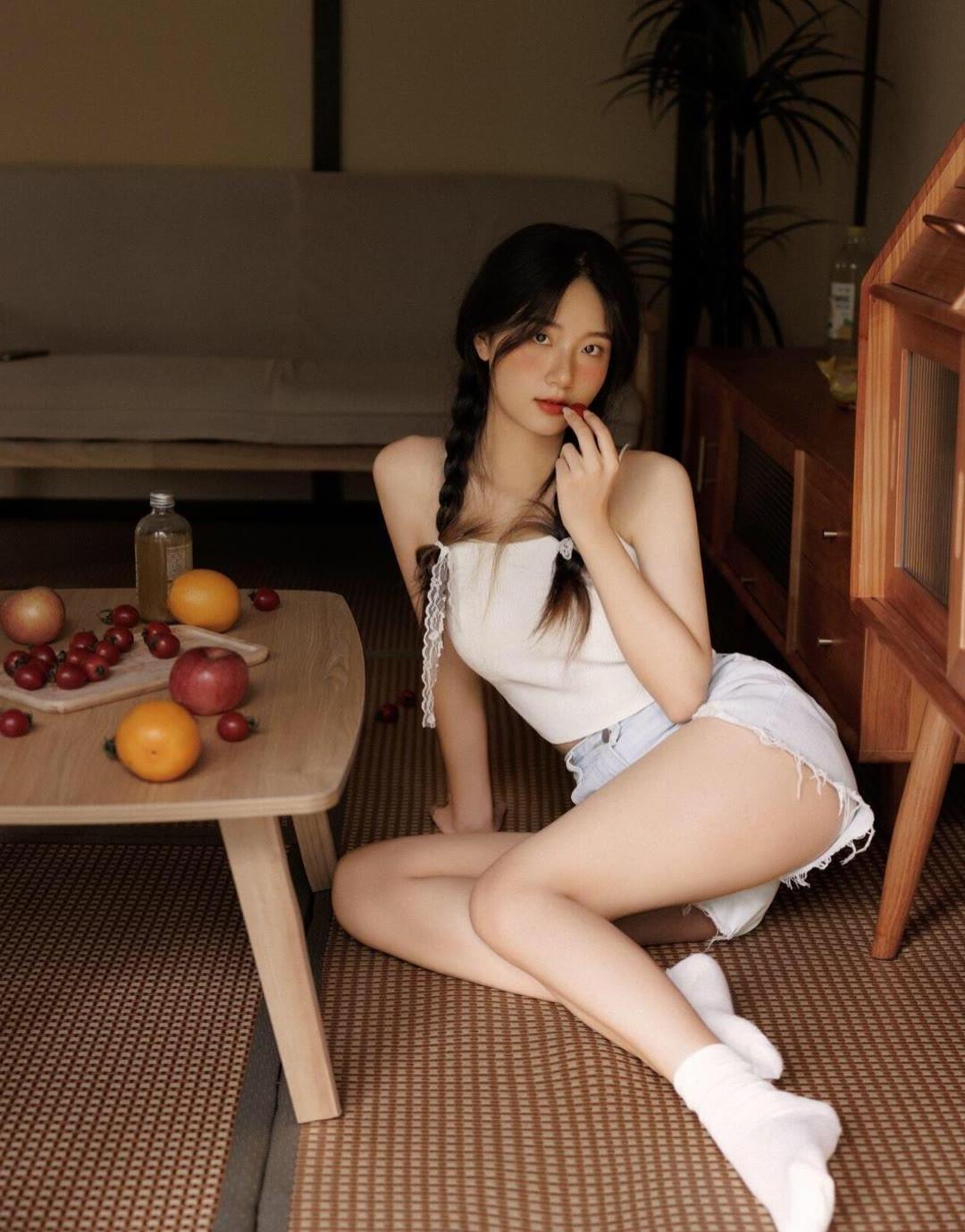 穿着白色的吊带背心，再配上一条牛仔短裤。坐在榻榻米上，伸出我的小脚丫，旁边桌子摆