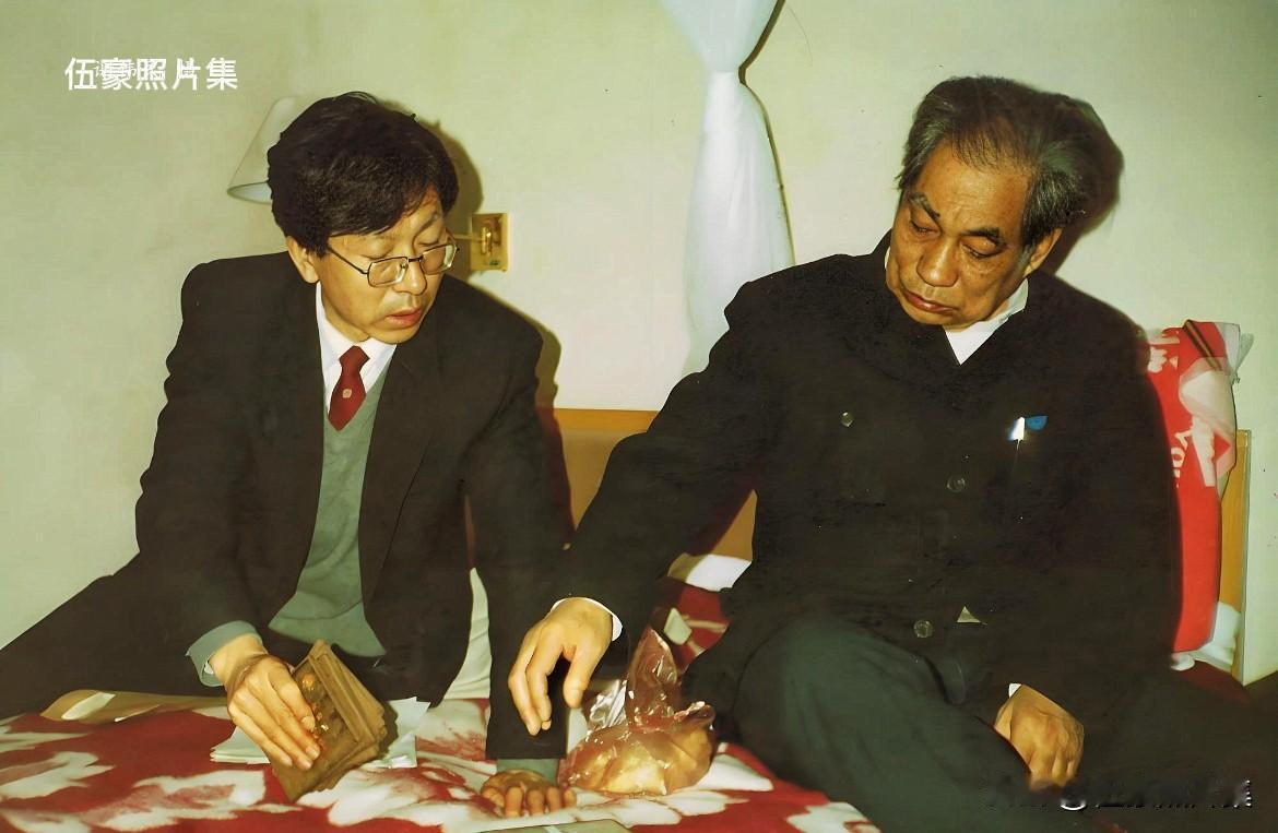 1988年12月3日，中国新闻摄影学会会长蒋齐生与学会秘书长胡颖正在为第三届全国