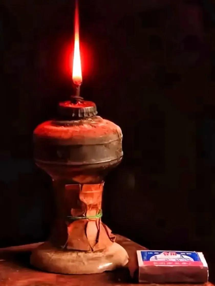 家中储物柜里摆着一盏老旧煤油灯，是上世纪六十年代传下来的老物件。铁皮灯身布满斑驳