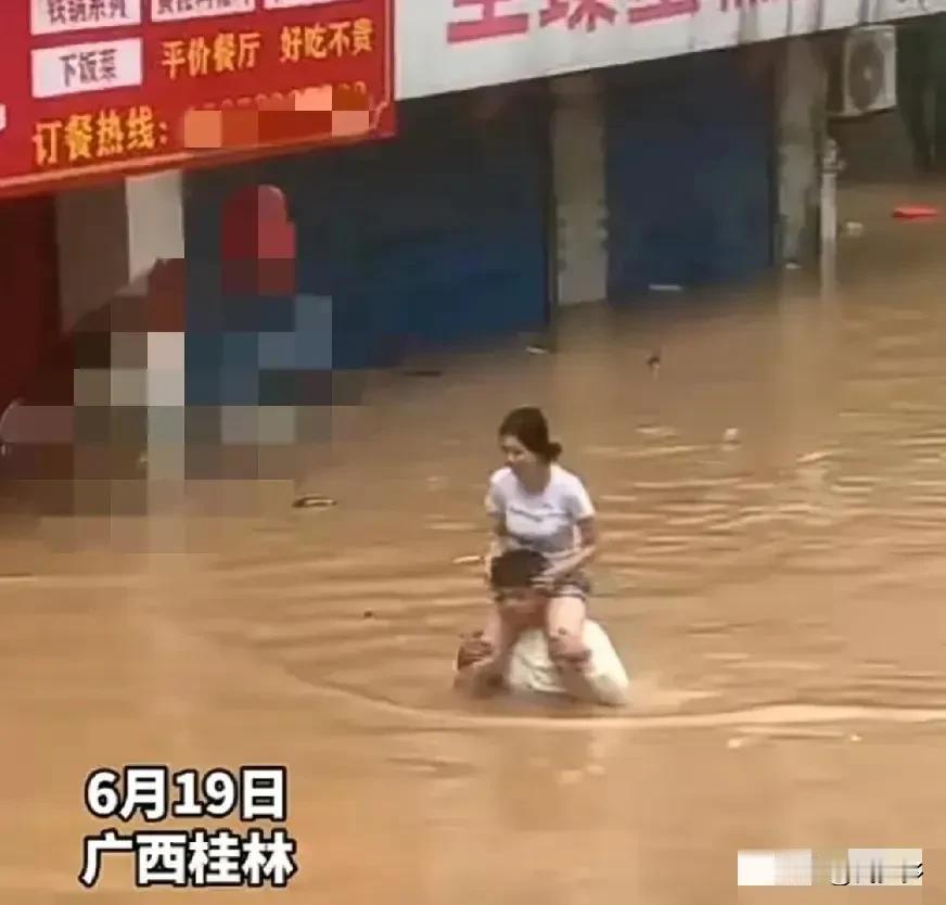 在暴雨后的深水中，
一个男人坐着一个女人的肩膀上，
仿佛他在用自己的生命支撑她，