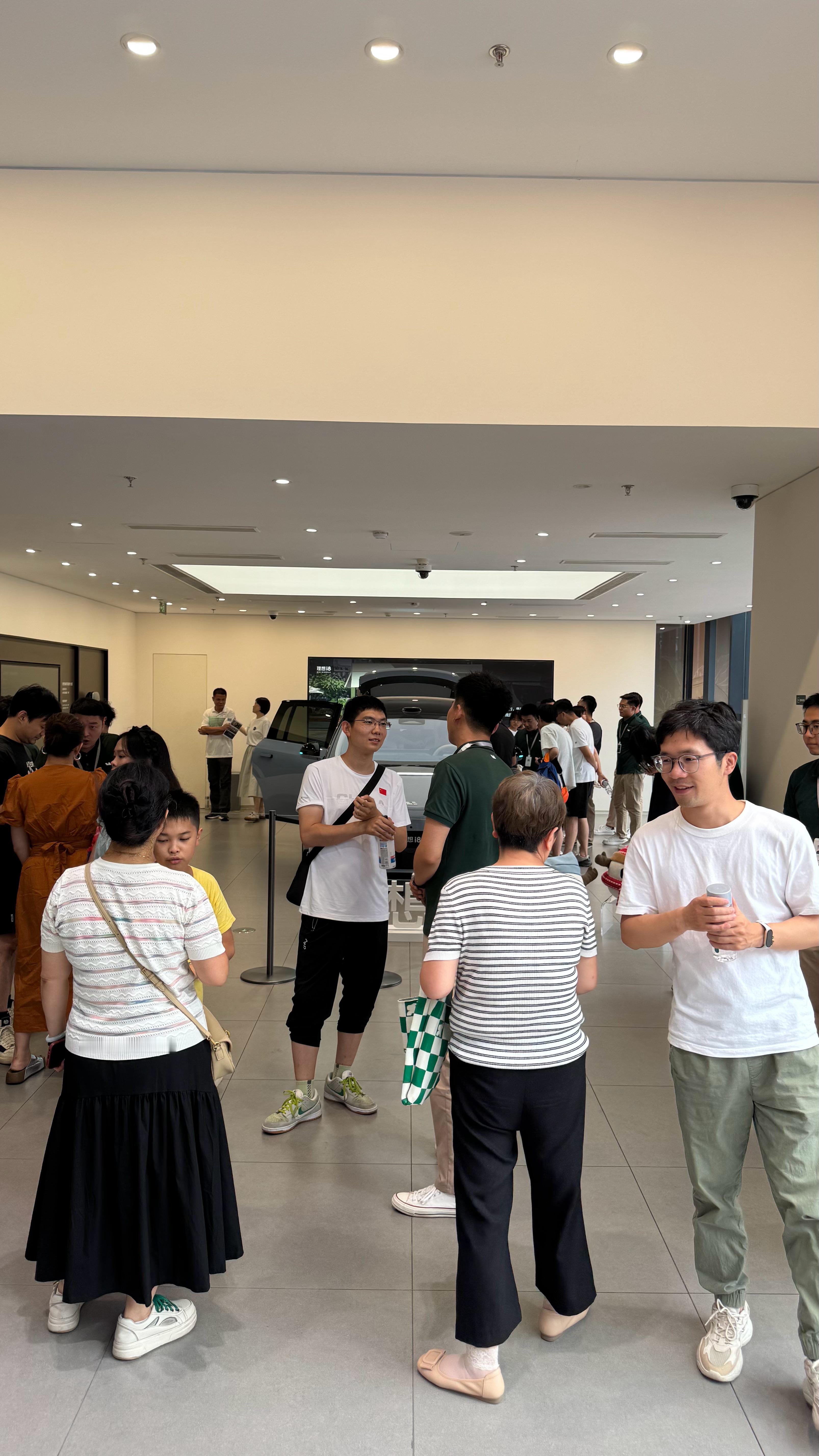 此刻的北京五棵松理想，i8看车排队情况，每组排队的用户都有一名销售在旁边提前讲解