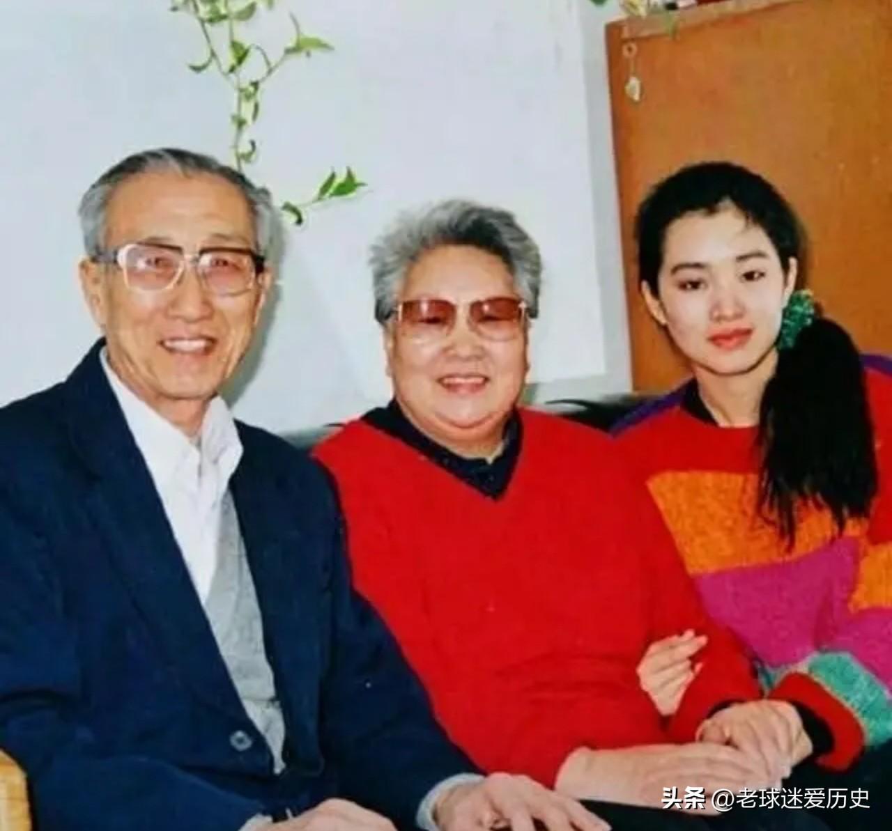 在这张九十年代的居家合影中，巩俐依偎在双亲身旁。
左侧，父亲身着深色西装，显得斯