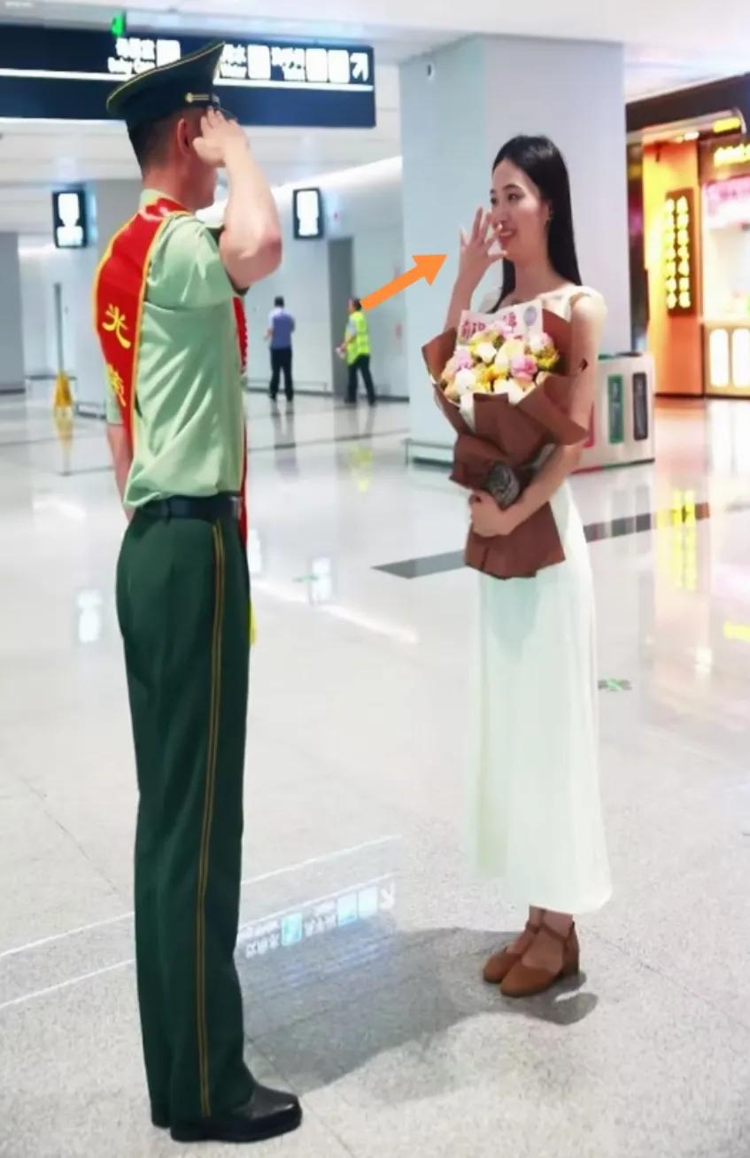 见到女友敬礼，女生用当手挡嘴乐开花儿了。