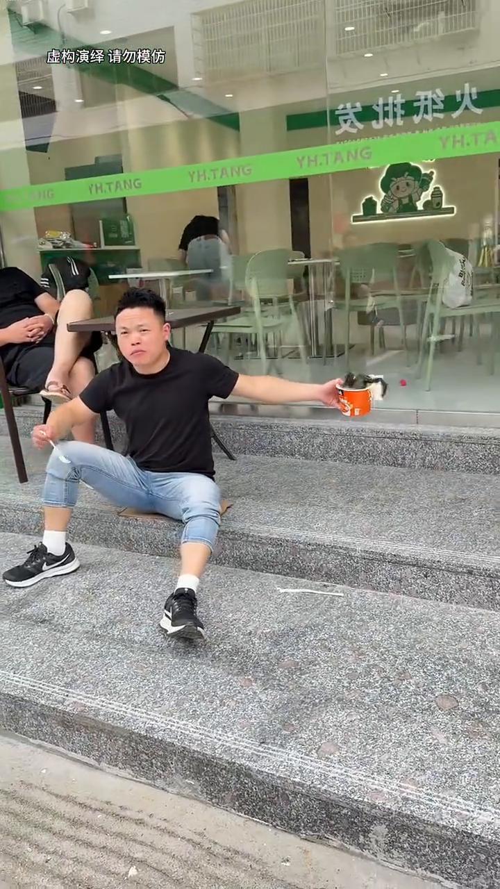 啊！
在奶茶店外的台阶上，一个男人为了喝到奶茶而努力。