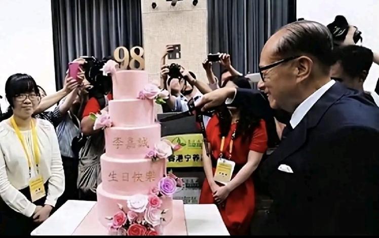 98岁的李嘉诚过生日，蛋糕的颜色是粉色的，还点缀着盛开的红玫瑰，充满了鲜活的生命