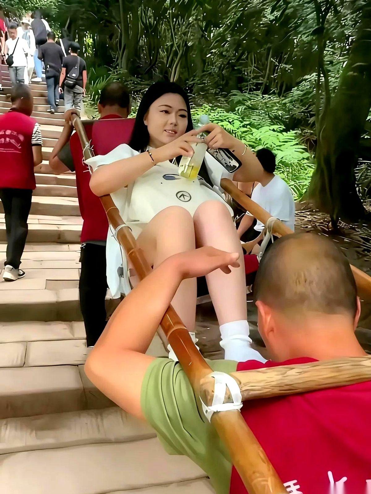 那姑娘拧瓶盖的样子，真悠闲啊。
可我一眼就看到了那个轿夫。
他半个身子都快拧成麻